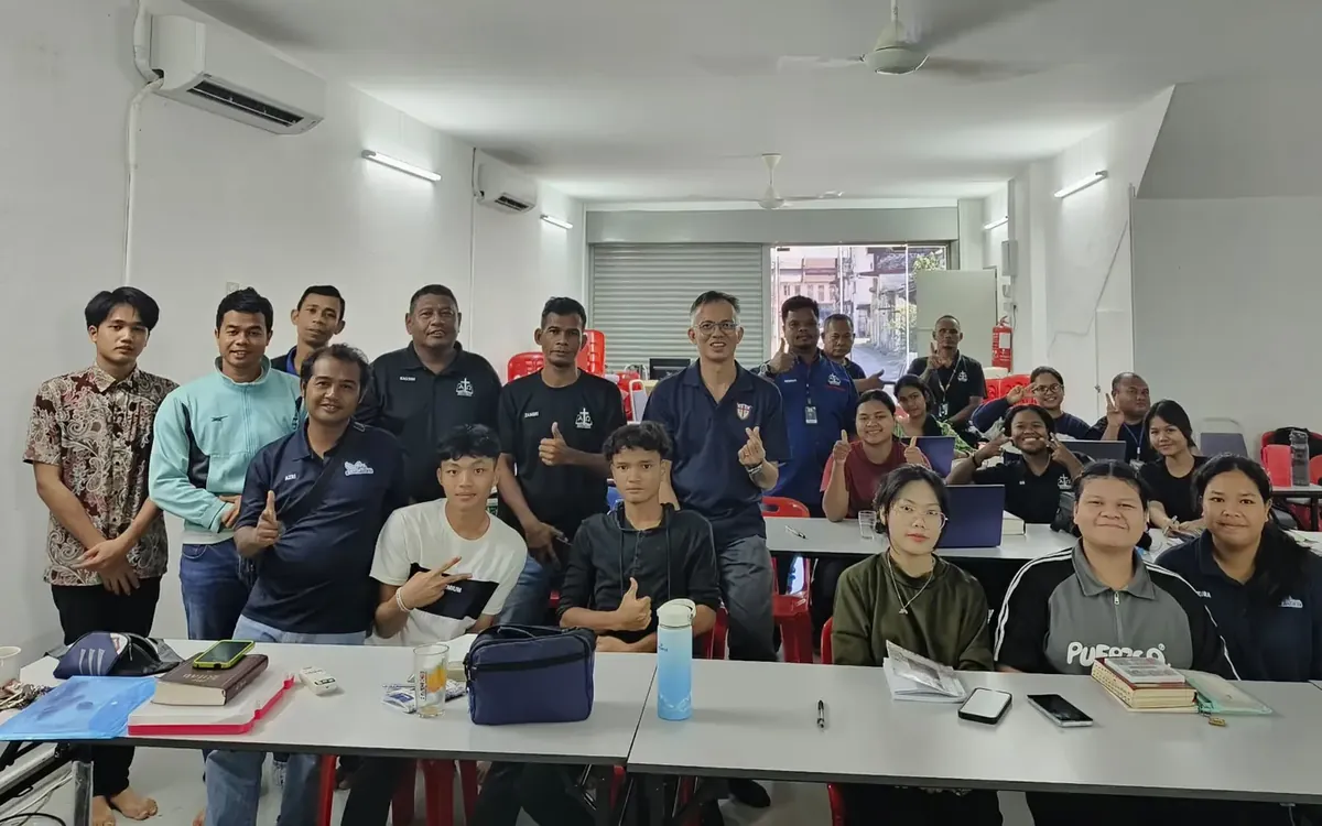 A group of adult students and leaders after a Zúme training session in a Bible school classroom